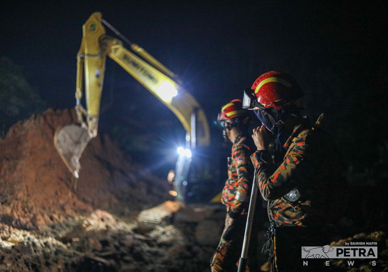 Dua orang anggota bomba memantau jengakaut mengali tanah untuk mencari mangsa tragedi tanah runtuh di Batang Kali. - Gambar oleh Sairien Nafis