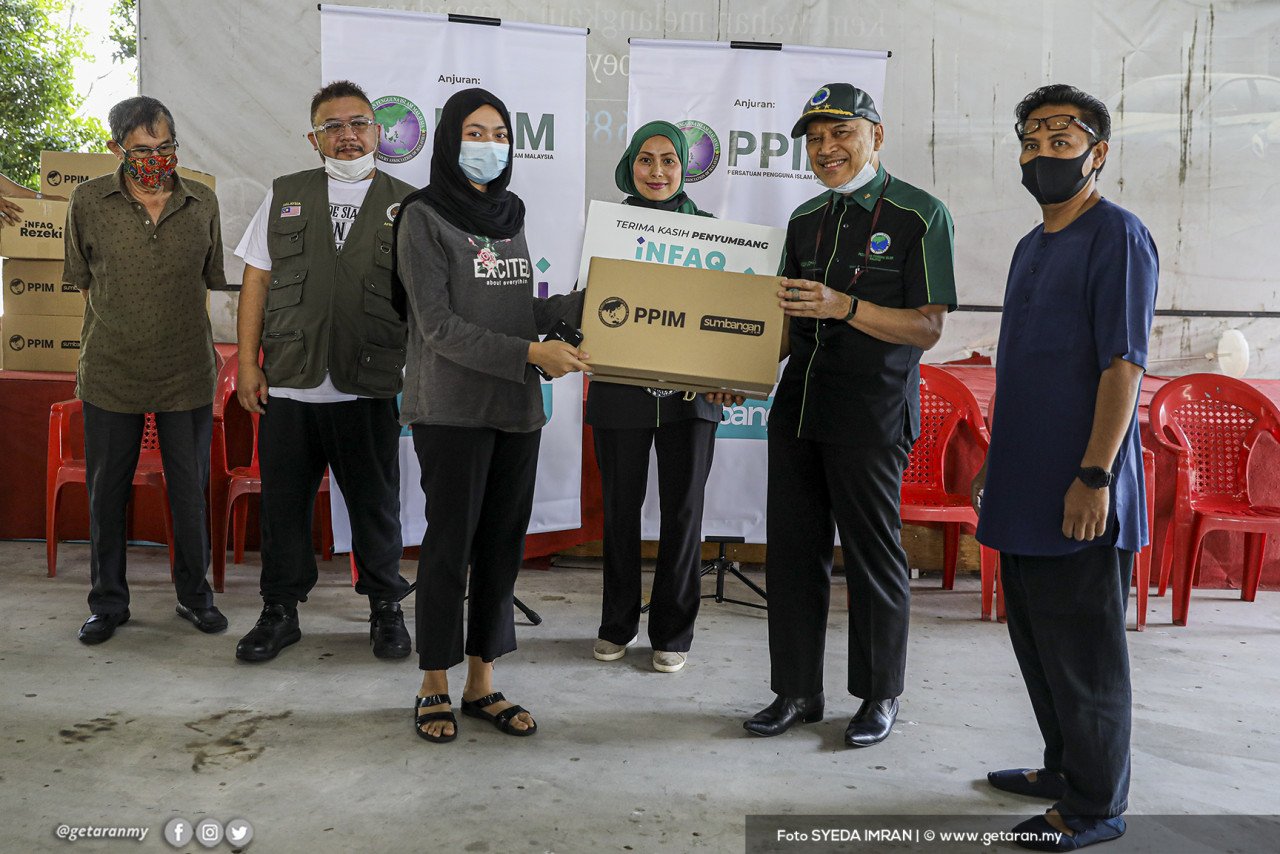 Pengerusi PPIM Datuk Nadzim Johan menyampaikan bantuan kepada penerima PPR Sungai Bunus Keramat. - Gambar oleh Syeda Imran