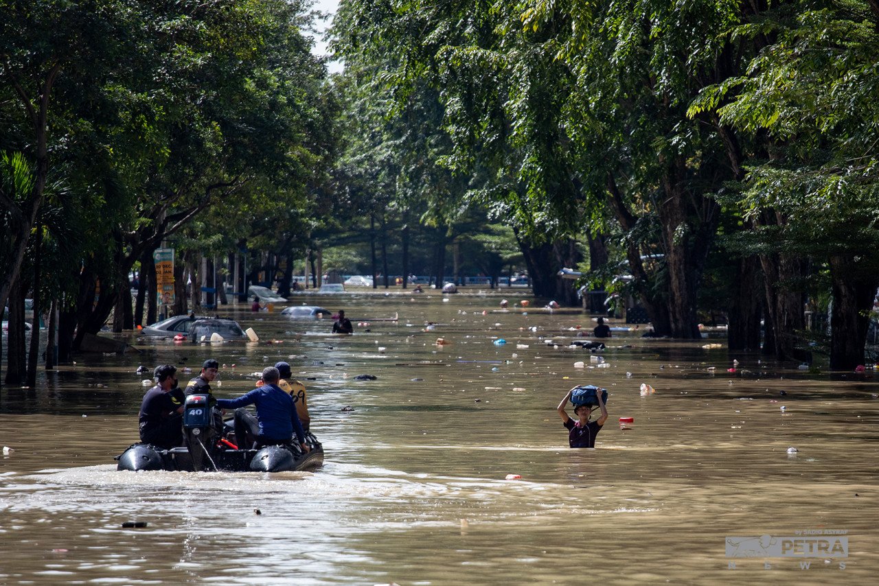 Pasukan menyelamat memindahkan mangsa banjir di Taman Sri Muda, Seksyen 25, Shah Alam, hari ini.
