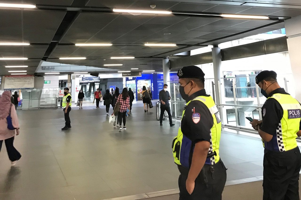 Polis berada di stesen LRT untuk membantu mengawal penumpang. - Gambar oleh Farah Deanna