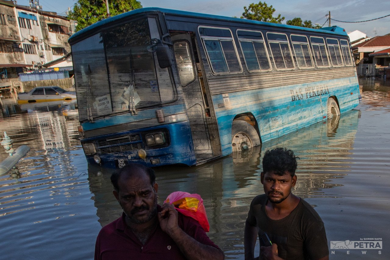 Sebuah bas kilang tersadai selepas ditenggelami air di Taman Sri Muda, Seksyen 25, Shah Alam.