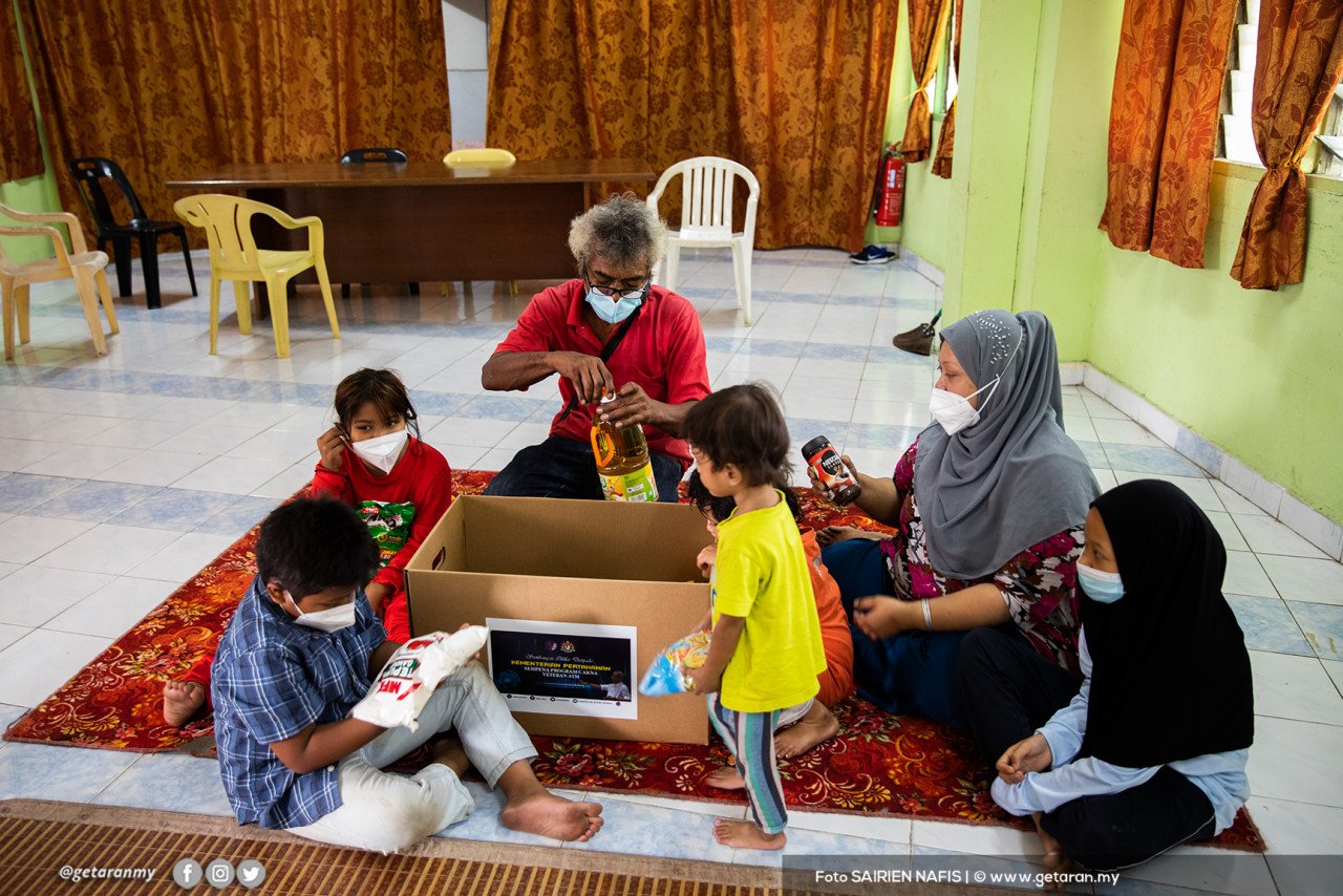Suria bersama keluarga memeriksa sumbangan barang keperluan di yang diterima di penempatan sementara Dewan Serbaguna Flat Seri Johor, Cheras. - Gambar oleh Sairien Nafis
