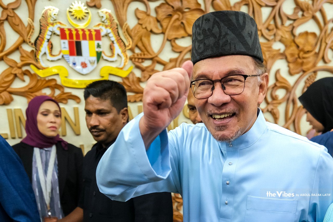 Anwar tersenyum sebaik keluar dari Dewan Rakyat selepas membentangkan Belanjawan 2023, di sini, hari ini. - Gambar oleh Abd Razak Latif