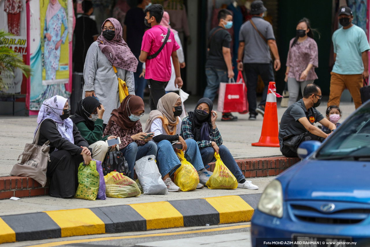 Sekumpulan pembeli-belah duduk berehat di tepi jalan. - Gambar oleh Azim Rahman