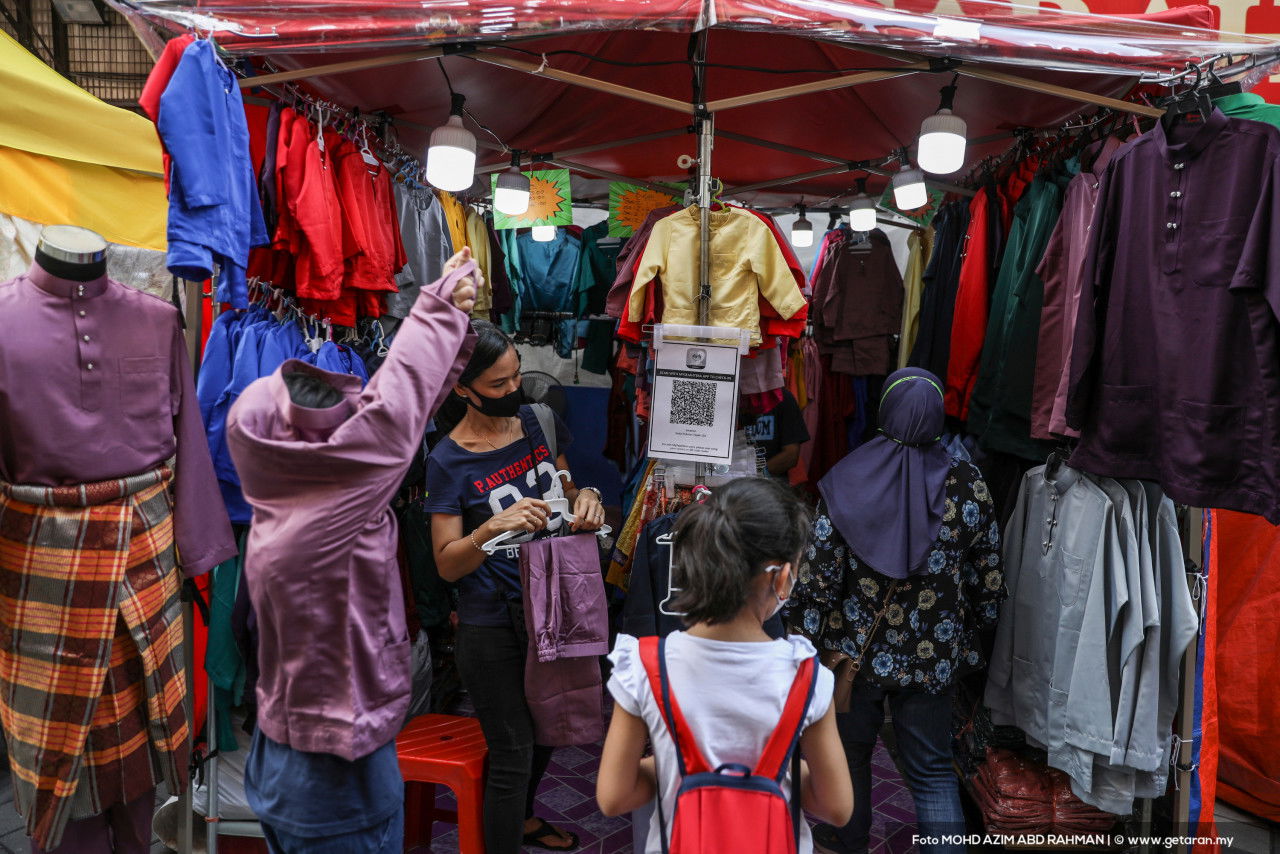 Satu keluarga membelek pakaian di gerai untuk persiapan raya. - Gambar oleh Azim Rahman