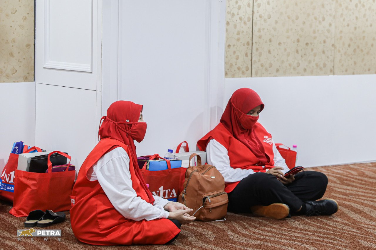 Ahli Wanita UMNO duduk di perkarangan foyer utama PWTC - Gambar Syeda Imran