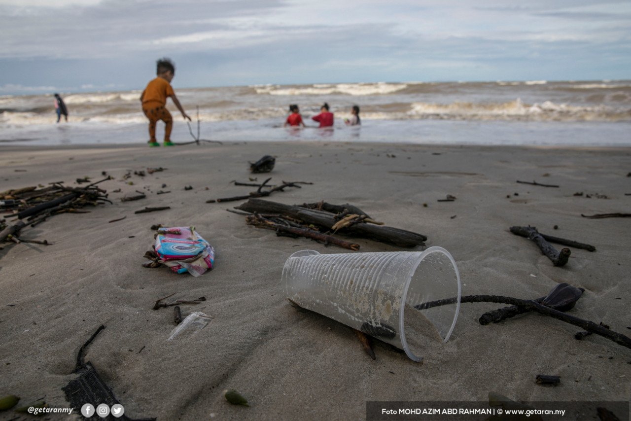 Kelihatan sampah-sarap bertaburan di Pantai Morib berlatarbelakangkan kanak-kanak mandi-manda. - Gambar oleh Azim Rahman