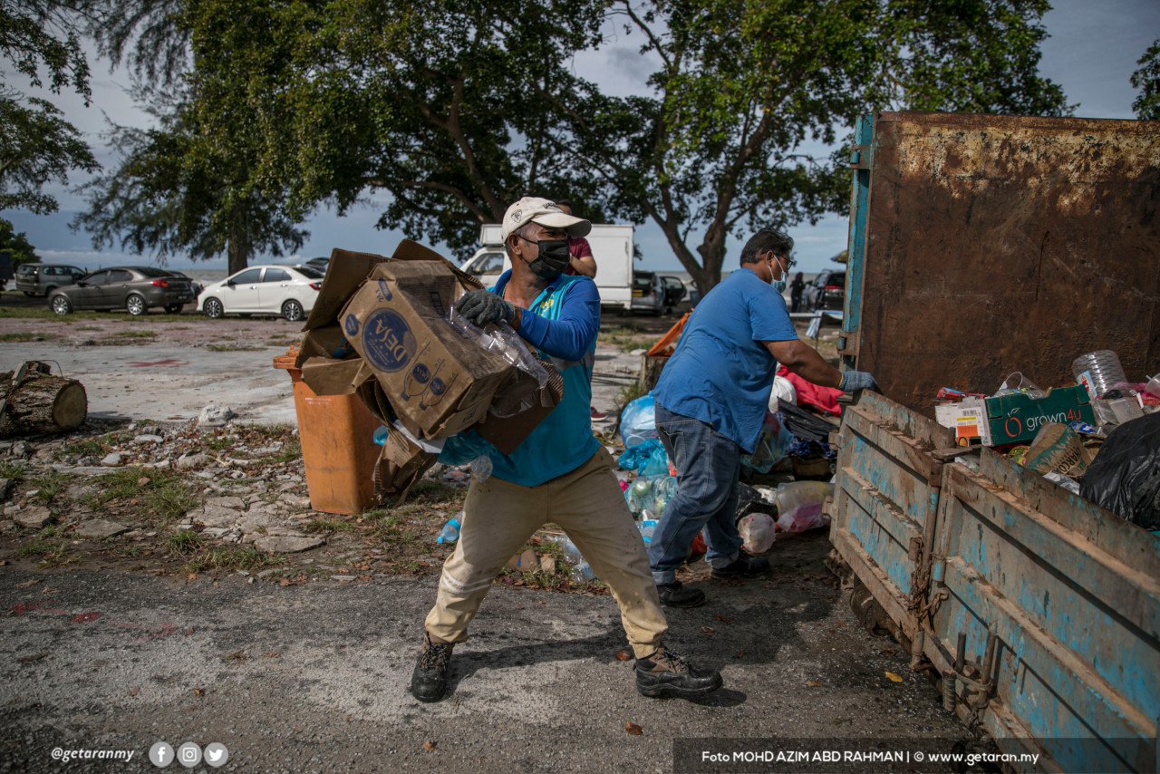 Pekerja kontrak megumpul sampah sarap di Pantai Morib. - Gambar oleh Azim Rahman