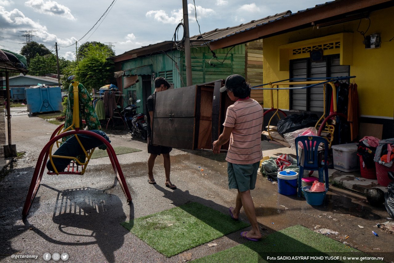 Dua penduduk di Kampung Kebun Bunga terpaksa menjemur almari kayu yang basah akibat ditenggelami air.
