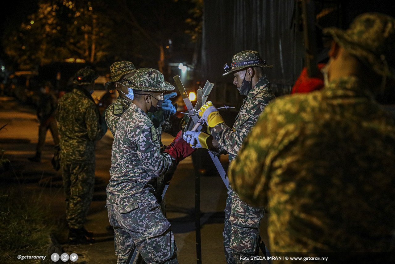 Anggota tentera memasang kawat berduri di Pangsapuri Permai.