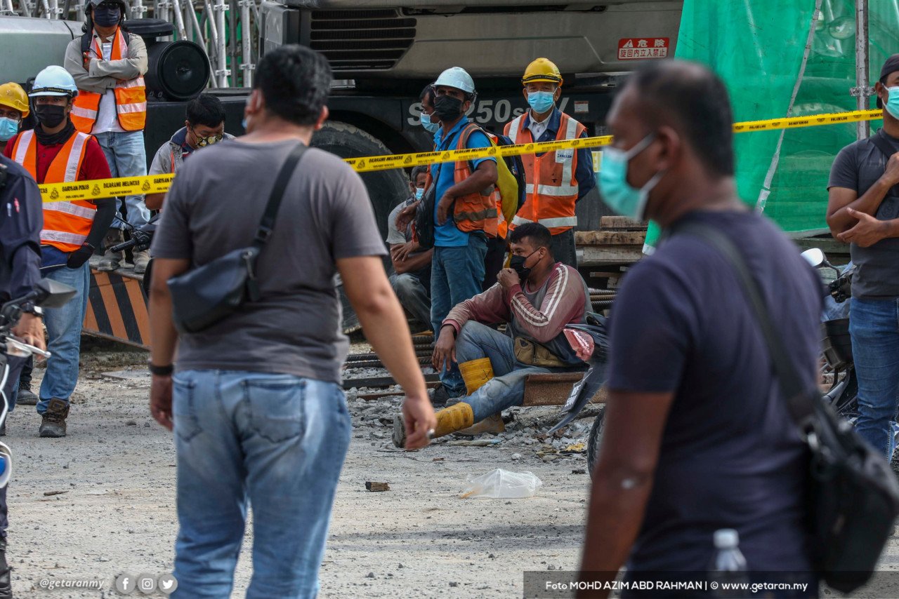 Kelihatan pekerja binaan berkumpul di tapak kejadian perencah pembinaan runtuh di Bandar Bukit Tinggi, Klang hari ini. - Gambar oleh Azim Rahman