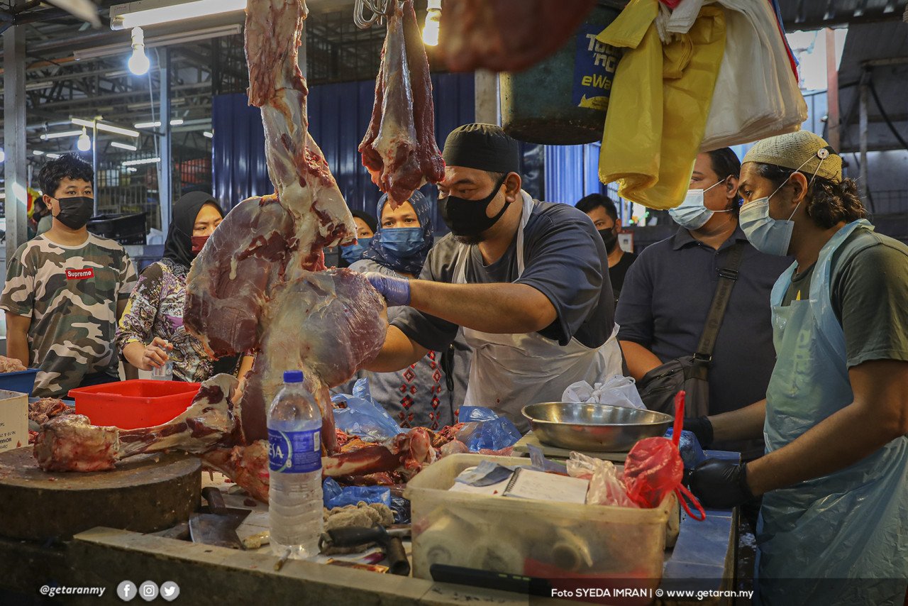 Orang ramai menunggu untuk membeli daging daripada seorang peniaga di Pasar Chow Kit.