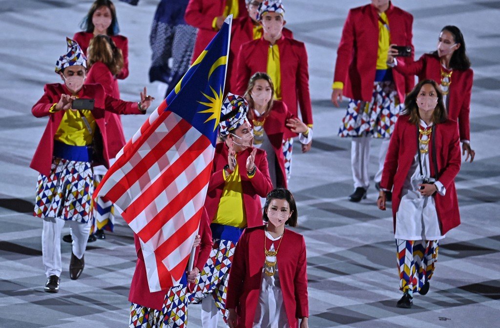 Kontinjen Malaysia seramai 13 peserta diketuai pemain badminton Lee Zii Jia dan Goh Liu Ying sebagai pembawa Jalur Gemilang, merupakan negara ke-177 berarak masuk ke stadium. - Gambar AFP
