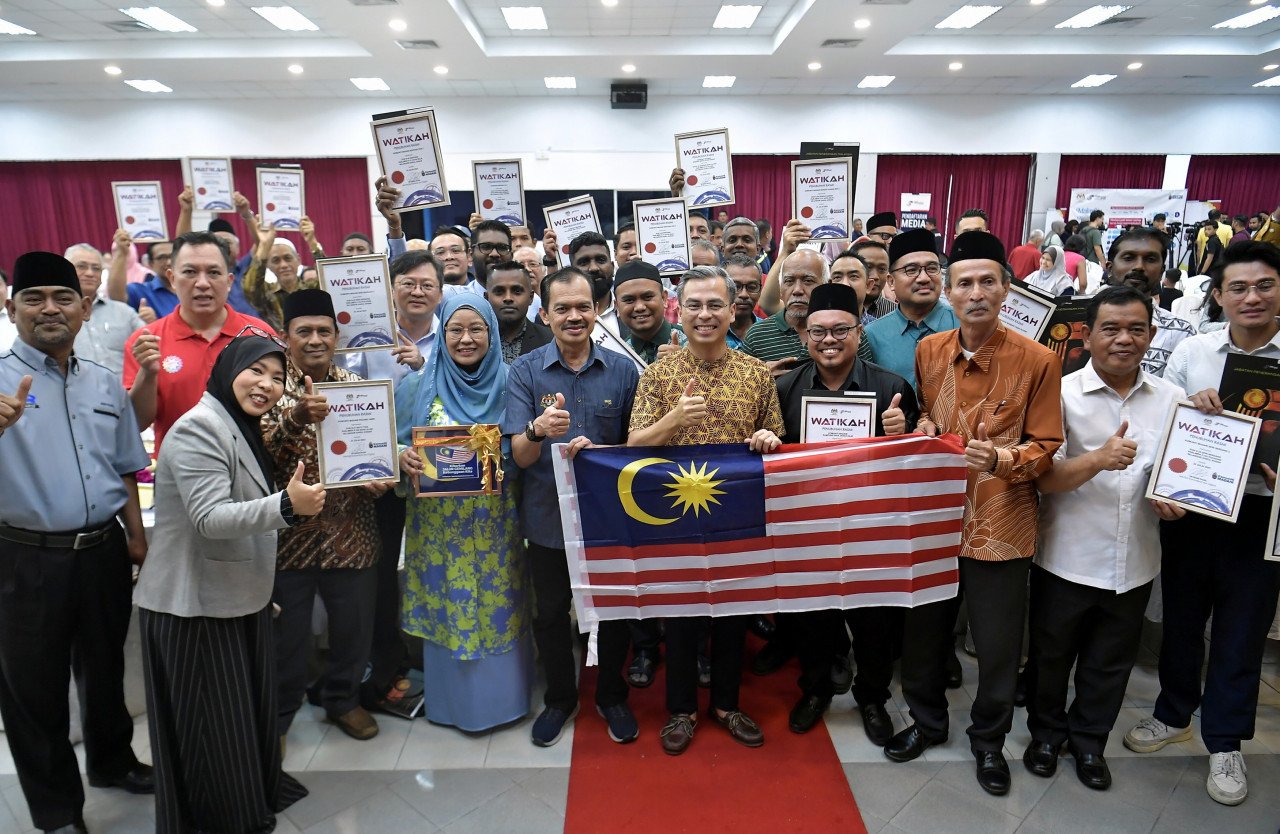 Fahmi Fadzil (tengah) bergambar bersama penerima watikah ketika menghadiri Majlis Penyerahan Watikah Komuniti MADANI Zon Tengah Negeri Selangor 2023 - gambar BERNAMA