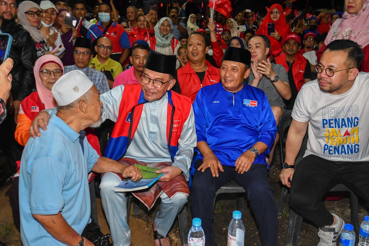 Anwar Ibrahim (dua, kiri) menyantuni penyokong parti yang hadir pada Ceramah Jelajah Perpaduan MADANI DUN Kota Lama di Medan Parkir KB - gambar BERNAMA