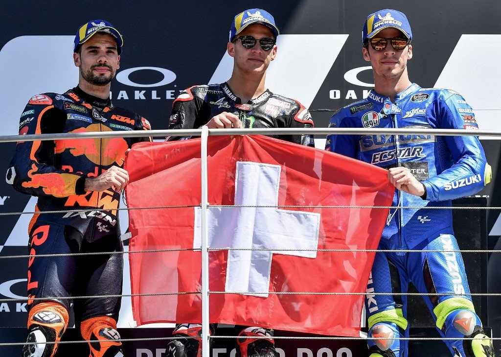 (Dari kiri) Oliveira, Quartararo, dan Mir bergambar bersama bendera Switzerland di atas podium sebagai tanda mengingati Jason Dupasquier. - Gambar AFP