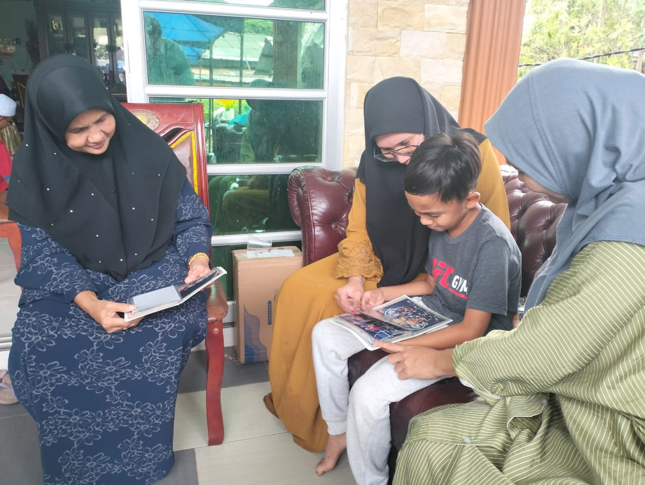 Muniroh Ahmad (kiri) melihat foto Muhammad Hattem bersama anak-anaknya - gambar Rafisqi Radhi