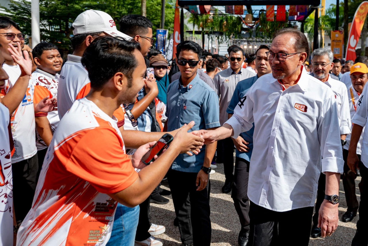 Perdana Menteri bersalaman dengan orang ramai ketika hadir merasmikan sambutan Hari FELDA - Gambar PMO