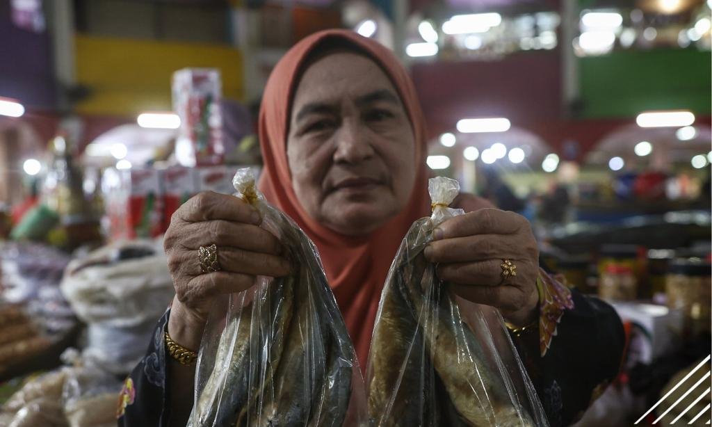 Rahmah Jaafar menunjukkan ikan budu kembung yang dijual - gambar BERNAMA