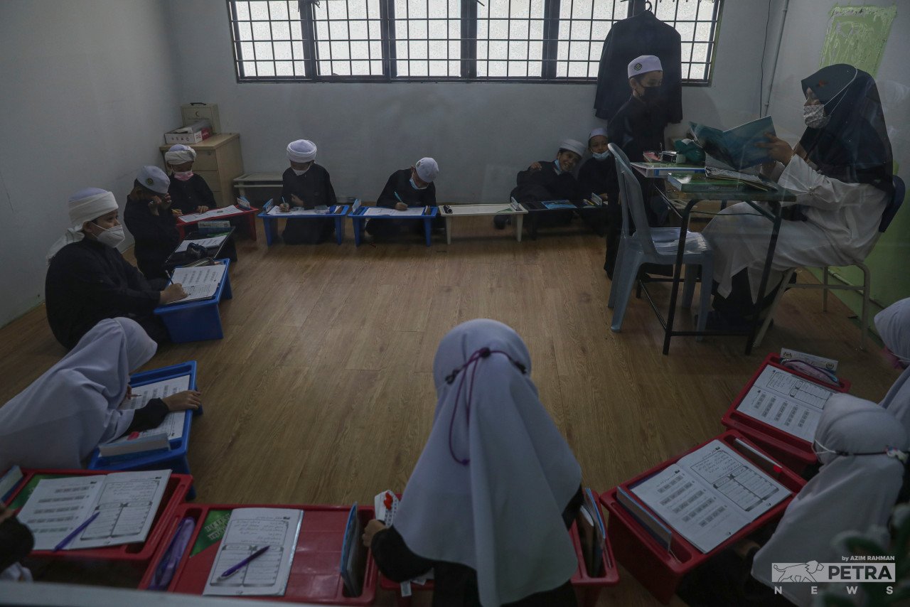 Guru Sekolah Islam Integrasi Tahfiz As-Syakirin di Alam Damai Cheras sedang mengajar pelajar membaca Al-Quran secara berkumpulan - gambar Azim Rahman