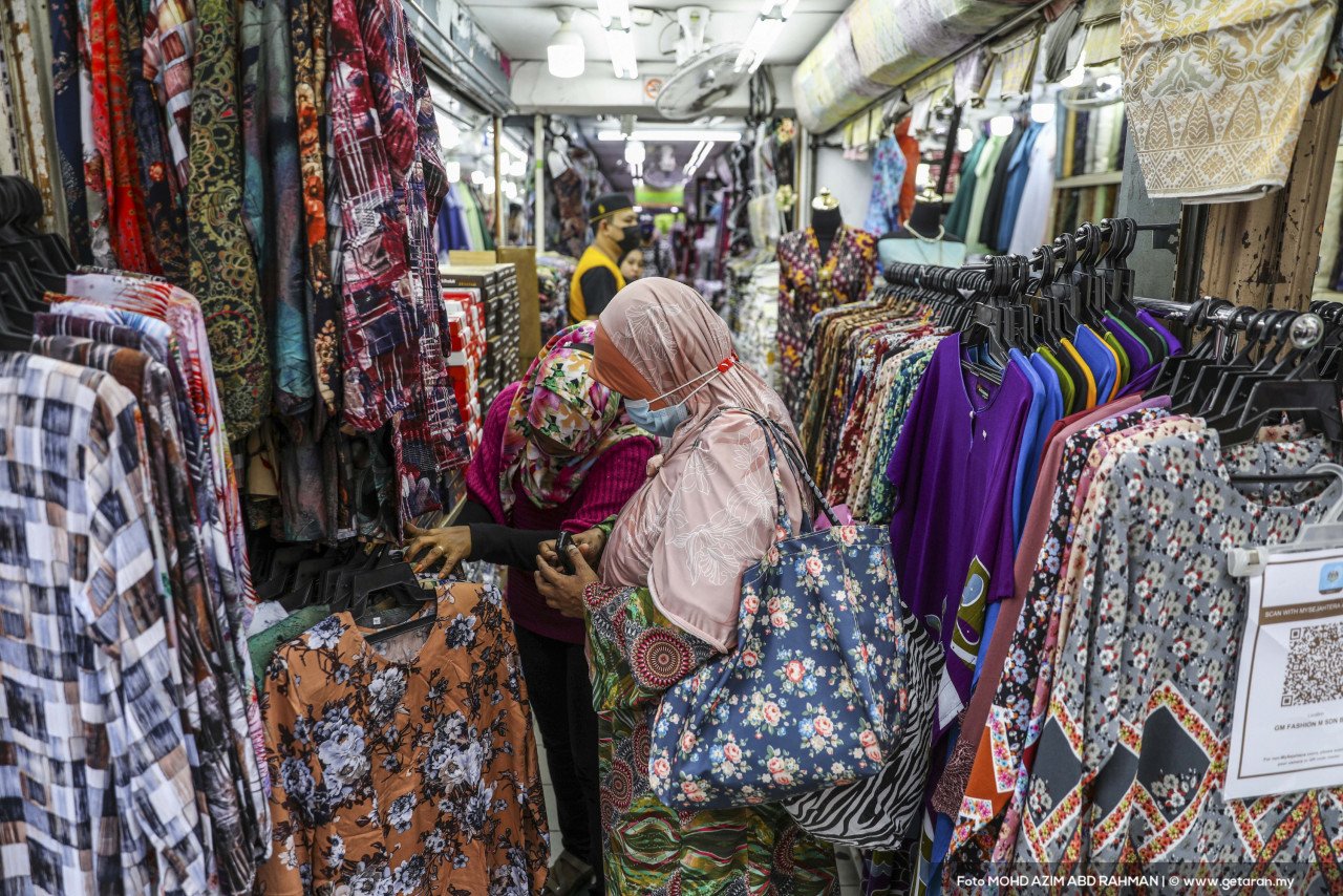 Pelanggan memilih baju yang sesuai untuk dibeli di sebuah gerai di Jalan TAR. - Gambar oleh Azim Rahman