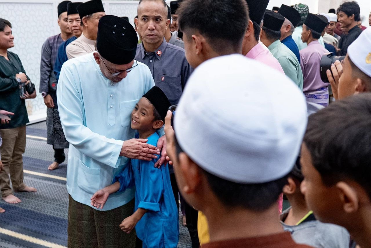 Perdana Menteri menyantuni seorang kanak-kanak lelaki pada Majlis Iftar MADANI semalam - gambar PMO