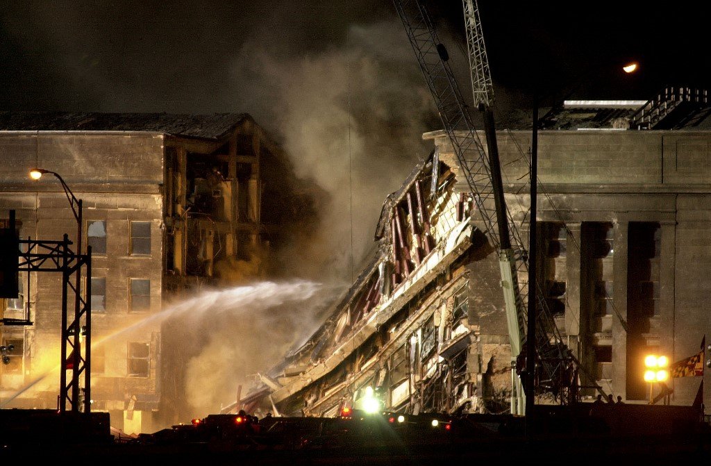 Bomba bertungkus lumus memadamkan sisa-sisa kebakaran di bangunan Pentagon di Washington, DC pada 13 September, 2001. - Gambar AFP