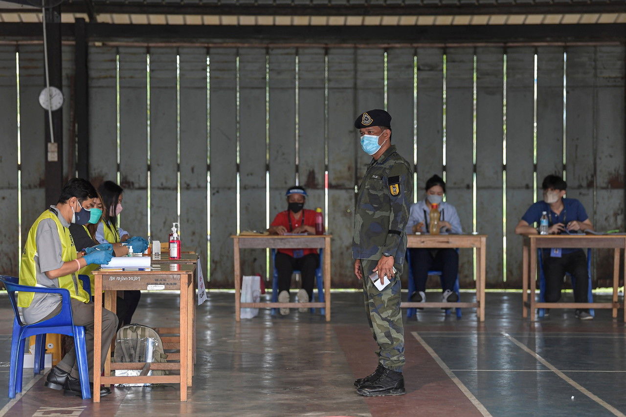 Petugas Suruhanjaya Pilihan Raya (SPR) sedang memantau proses pencelupan jari bagi anggota Pasukan Gerakan Am (PGA) sebelum memangkah kertas undi untuk proses pengundian awal Dewan Undangan Negeri (DUN) N.52 Dudong. - Gambar Bernama