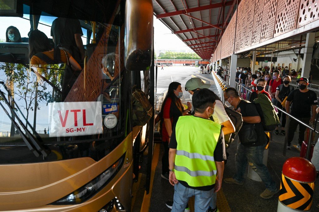 Orang ramai menaiki bas yang menghala ke Johor dari Singapura di bawah program VTL pada 29 November. - Gambar AFP