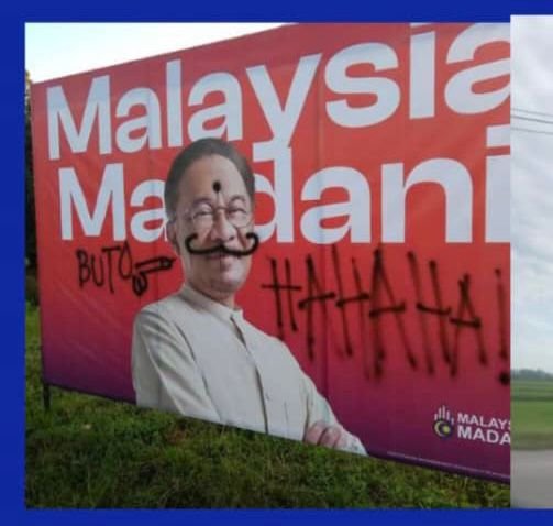 Papan tanda memaparkan wajah PM yang diconteng 