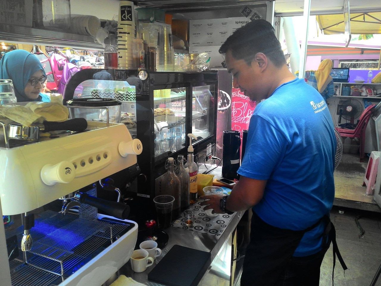 Zainul Ariffin melayan pelanggannya yang datang untuk membeli kopi.