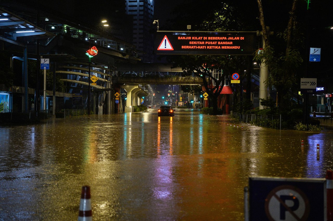 Banjir kilat akibat limpahan air sungai dan perparitan mengakibatkan beberapa jalan di sekitar ibu kota ditenggelami air, malam tadi. - Gambar Bernama 