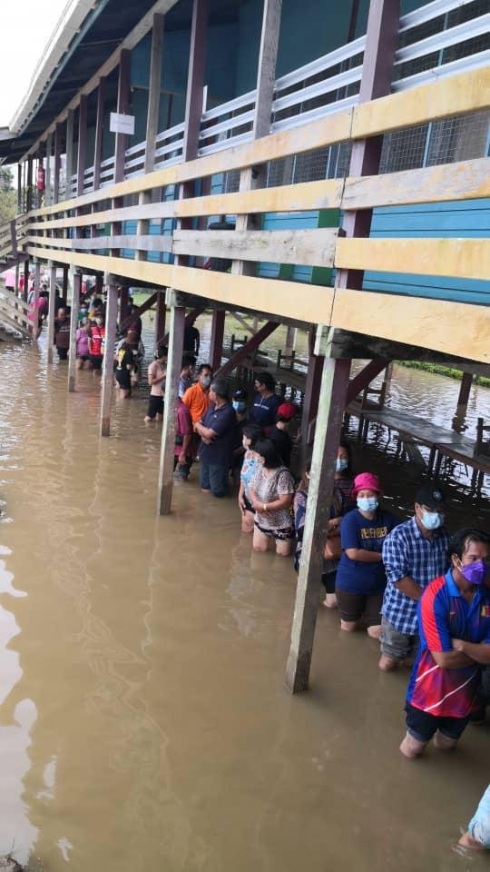Pengundi di pusat mengundi Baram, Sarawak beratur dalam banjir paras lutut ketika menunggu giliran membuang undi bagi kerusi Parlimen - Gambar media sosial