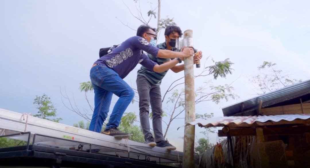 Sukarelawan URT Aslam Resources memasang lampu solar.