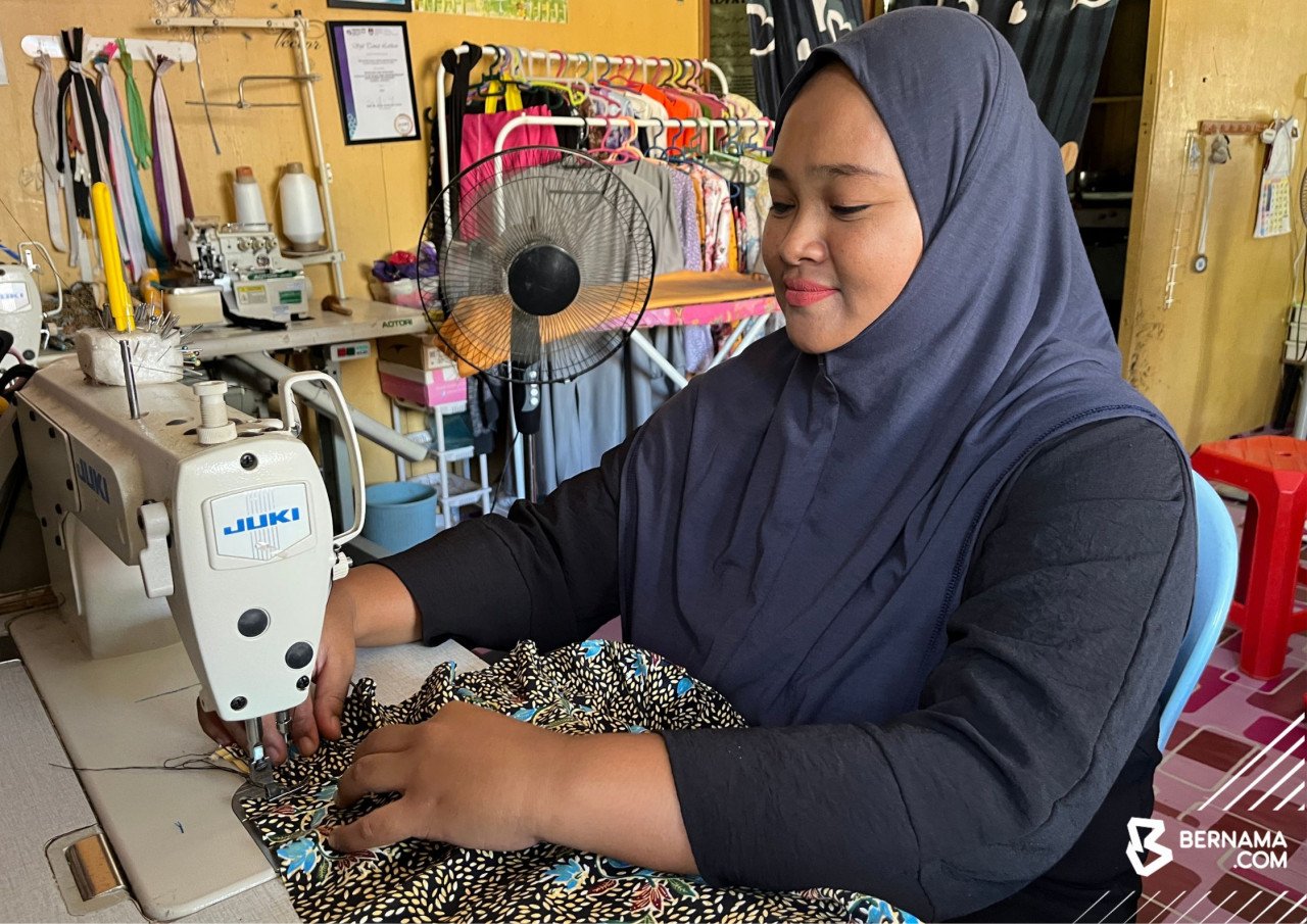 Siti Norsyakila Kamarzaman menyiapkan tempahan baju raya pelanggannya di rumahnya di Kampung Lambok, Rancangan Pengumpulan Semula (RPS) Kuala Betis, Gua Musang.